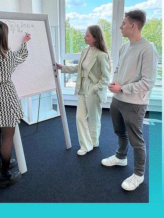Auszubildende Jessica und Alex an einem Flipchart