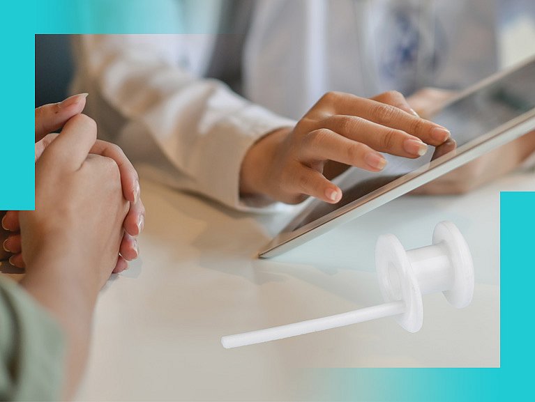 Ärztin bedient Tablet, daneben liegt eine Stimmprothese
