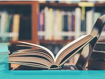 Buch auf Laptop in einer Bibliothek